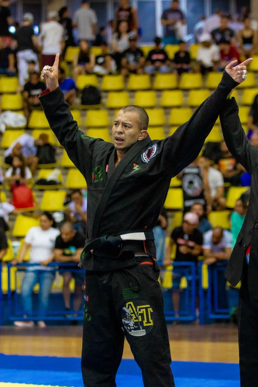 Juliano Alicate de braços erguidos comemorando vitória de kimono
